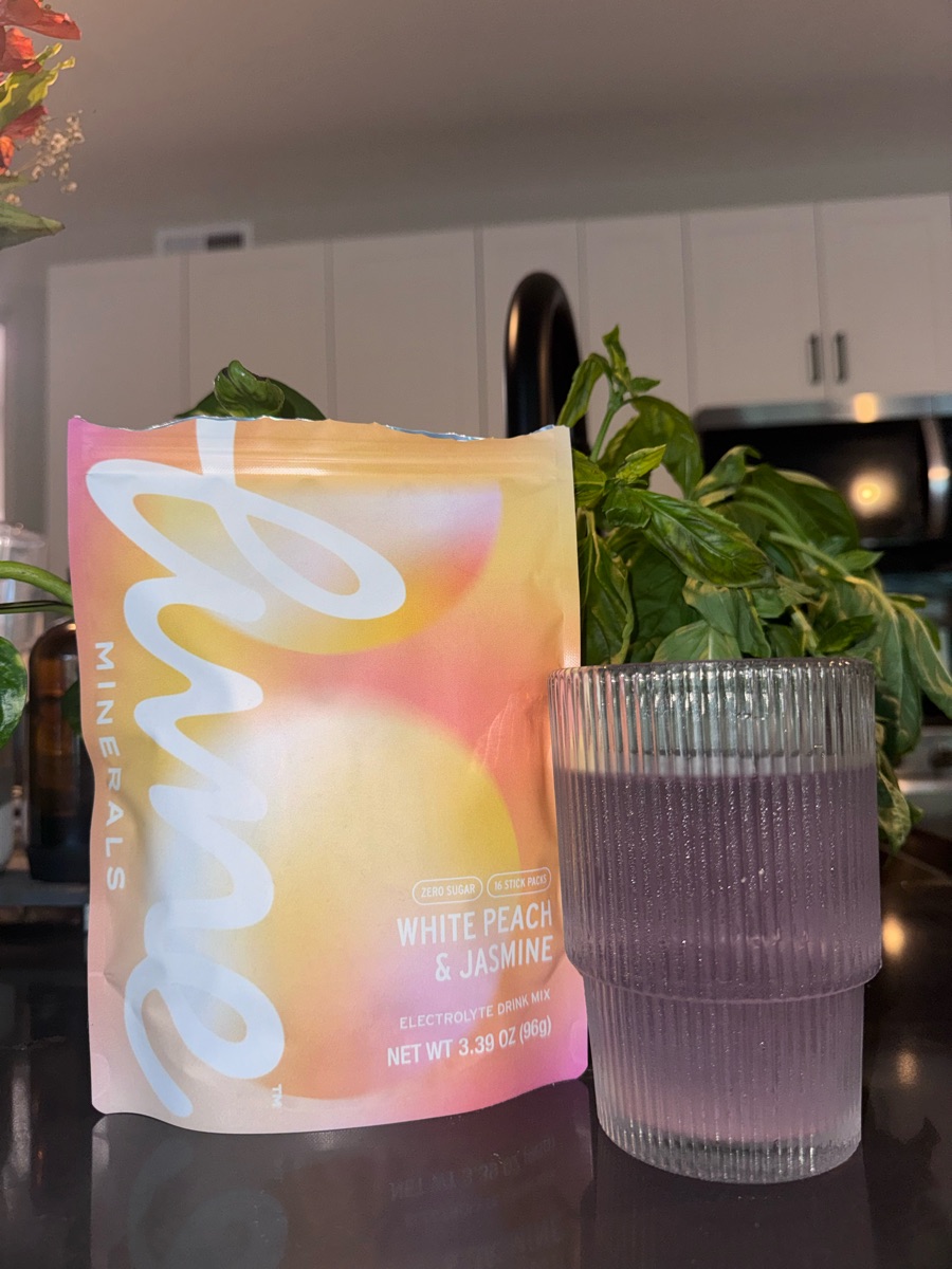 Customer photo: a White Peach & Jasmine pouch next to a glass of the mixed drink